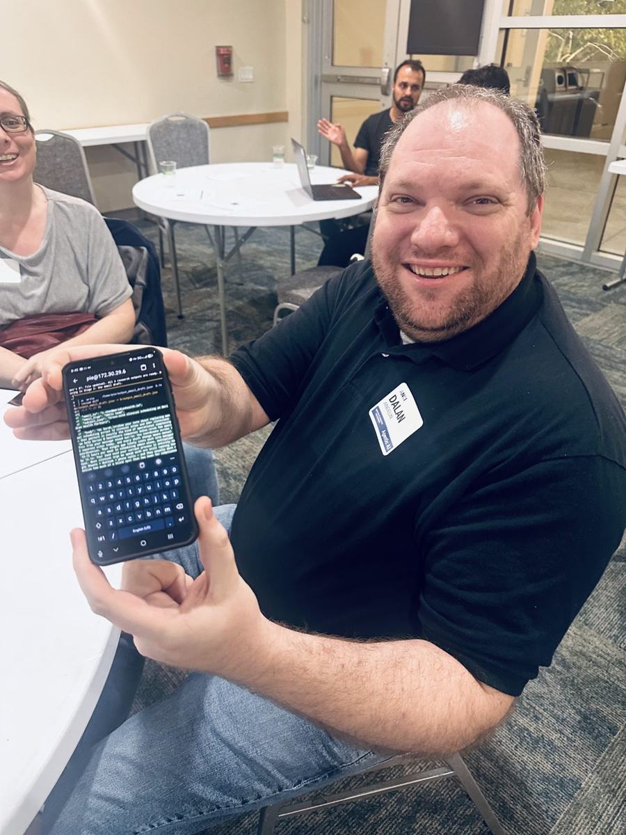 An attendee grinning while holding up his phone showing the agent output he just generated.